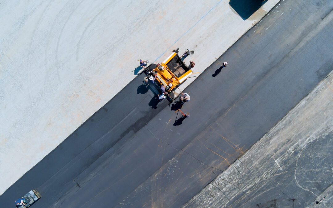 Roadwork team is ensuring that parking lot is properly prepared before applying asphalt layer near shopping mall center